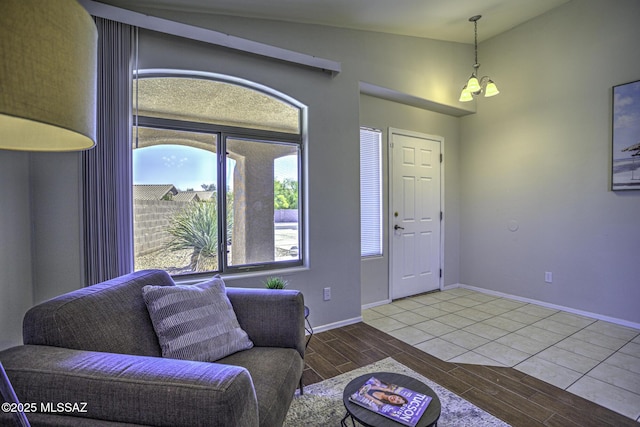 living room featuring baseboards, lofted ceiling, and wood finish floors