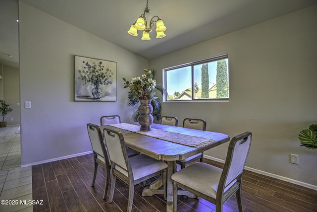 dining area with a notable chandelier, baseboards, wood tiled floor, and lofted ceiling