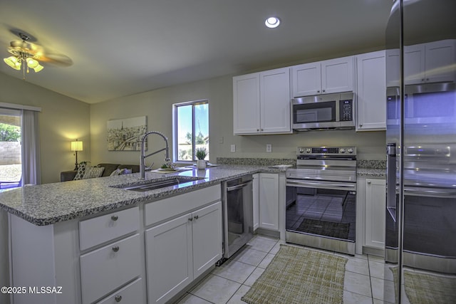 kitchen featuring a peninsula, a ceiling fan, white cabinets, appliances with stainless steel finishes, and a sink