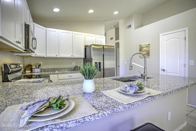 kitchen featuring visible vents, a sink, appliances with stainless steel finishes, recessed lighting, and vaulted ceiling