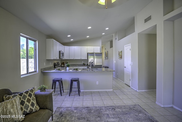 kitchen with recessed lighting, a peninsula, light tile patterned floors, and appliances with stainless steel finishes