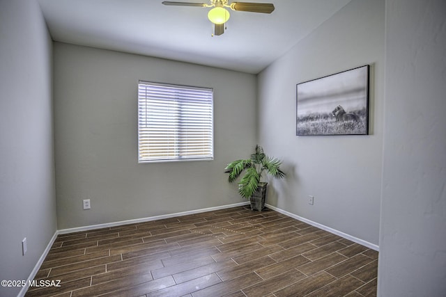 spare room featuring baseboards, a ceiling fan, and dark wood-style floors