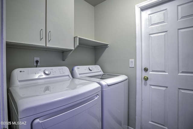 clothes washing area with cabinet space and washing machine and dryer