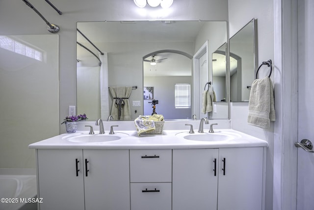 full bath with walk in shower, double vanity, a sink, and ceiling fan