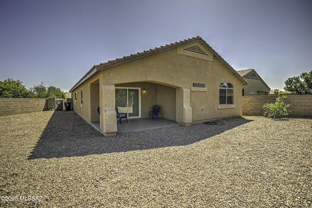 back of property featuring a patio area, a fenced backyard, a tiled roof, and stucco siding