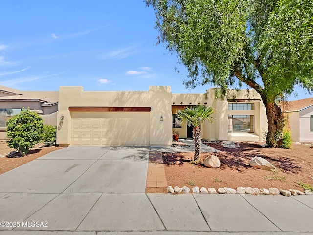 pueblo revival-style home featuring a garage