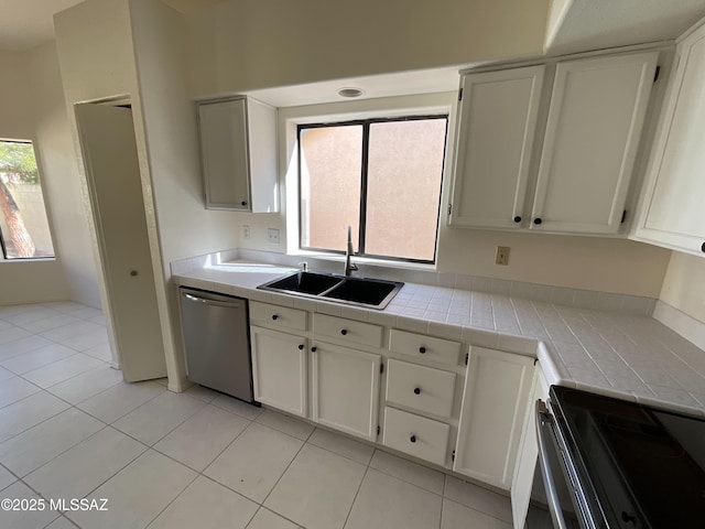 kitchen with sink, white cabinetry, electric range, stainless steel dishwasher, and tile counters