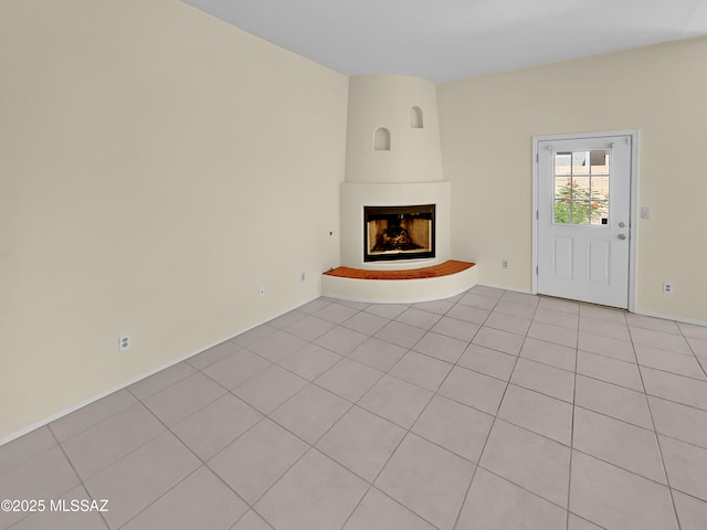 unfurnished living room featuring a fireplace and light tile patterned floors