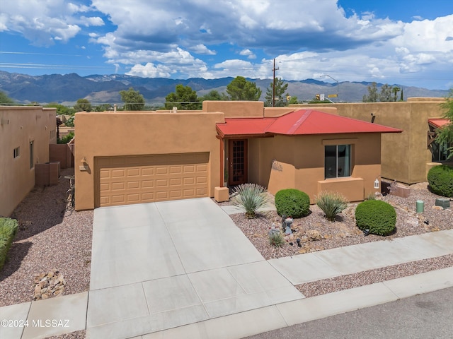 pueblo-style home with a mountain view and stucco siding