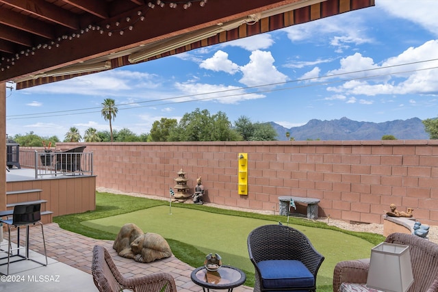 view of yard with a patio area, a fenced backyard, and a mountain view