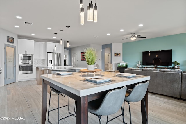 dining room with arched walkways, visible vents, ceiling fan, and recessed lighting