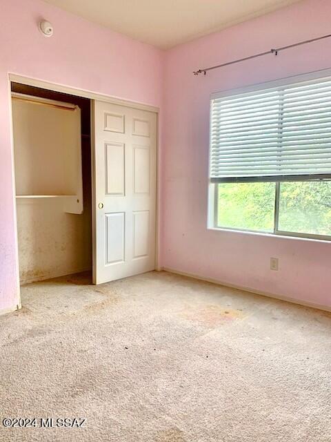 unfurnished bedroom with carpet flooring and a closet