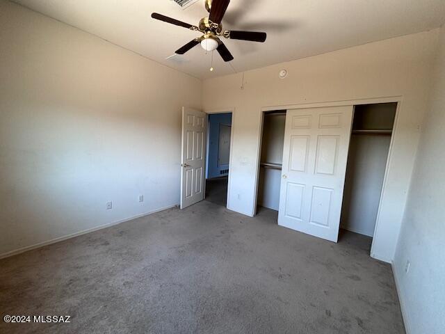 unfurnished bedroom with ceiling fan, carpet floors, and a closet