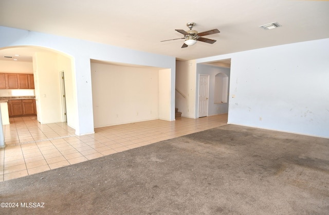 spare room with ceiling fan and light carpet