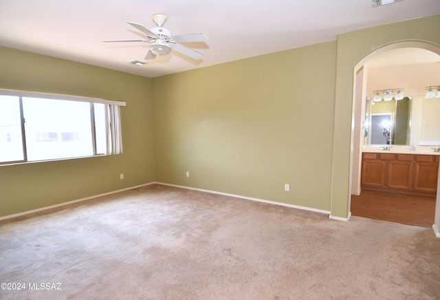 empty room featuring ceiling fan, sink, and light carpet