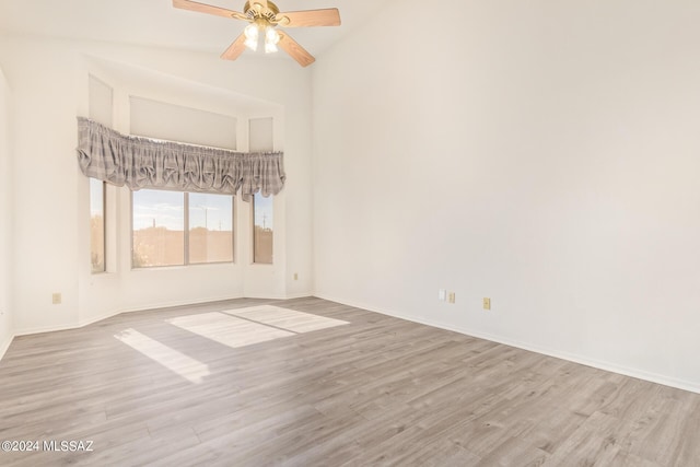 unfurnished room featuring high vaulted ceiling, baseboards, ceiling fan, and wood finished floors