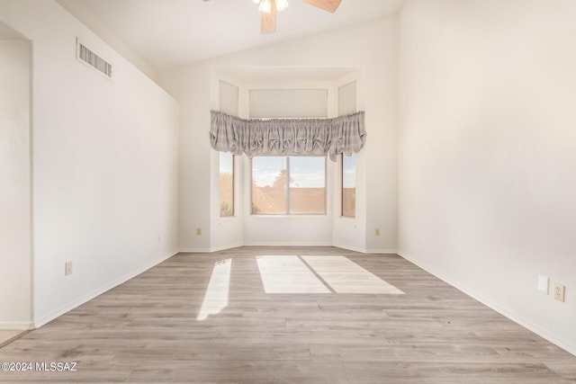 empty room with baseboards, visible vents, wood finished floors, and ceiling fan