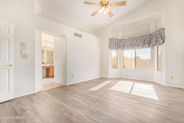 spare room featuring high vaulted ceiling, light wood-style flooring, visible vents, baseboards, and ceiling fan