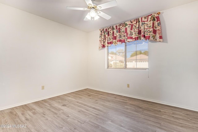 unfurnished room with baseboards, ceiling fan, and wood finished floors