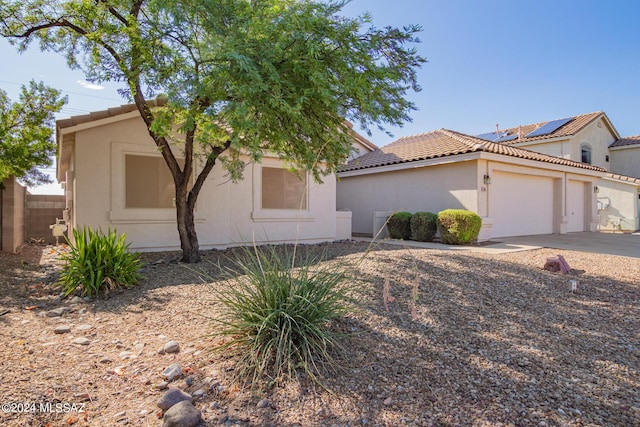 view of front of house with a tiled roof, stucco siding, driveway, and a garage