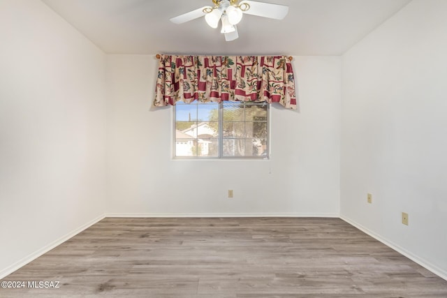 unfurnished room with baseboards, wood finished floors, and a ceiling fan