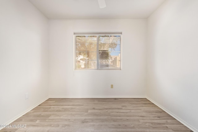 unfurnished room with baseboards, wood finished floors, and ceiling fan