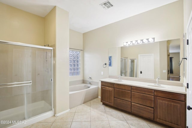 bathroom with tile patterned flooring, independent shower and bath, and vanity