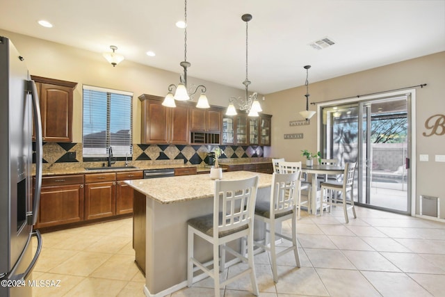 kitchen with plenty of natural light, sink, tasteful backsplash, and a kitchen island