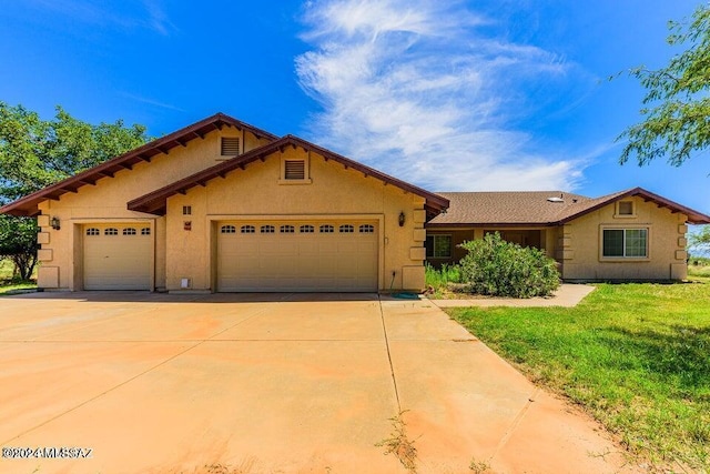 view of front of house featuring concrete driveway, stucco siding, a front yard, and a garage