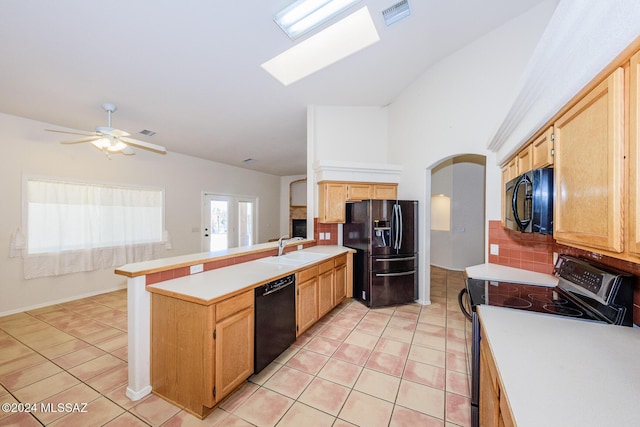 kitchen featuring backsplash, visible vents, a sink, black appliances, and a peninsula