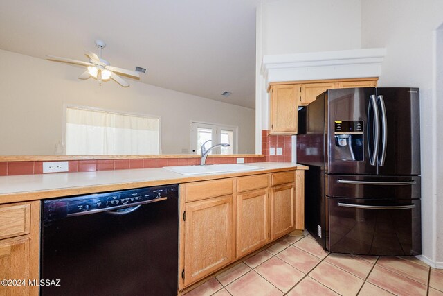 kitchen featuring light tile patterned flooring, black dishwasher, light countertops, fridge with ice dispenser, and a sink