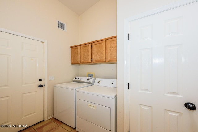 clothes washing area with visible vents, cabinet space, light tile patterned floors, and washing machine and dryer
