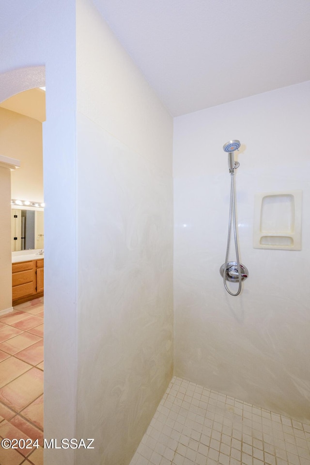 bathroom featuring tile patterned flooring, walk in shower, and vanity