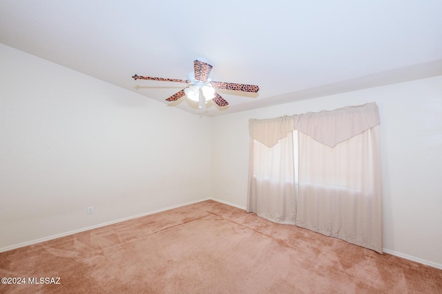 spare room featuring carpet floors, baseboards, and ceiling fan