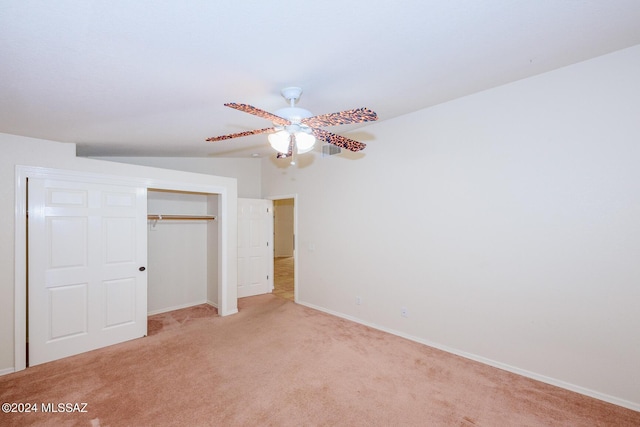 unfurnished bedroom with light colored carpet, baseboards, ceiling fan, and a closet