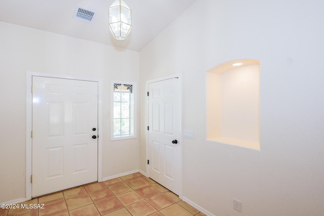 foyer featuring light tile patterned floors, baseboards, and visible vents
