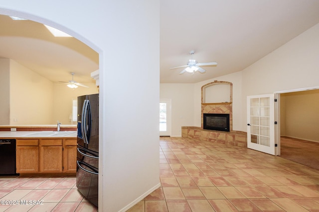 kitchen featuring a sink, tile countertops, black appliances, and ceiling fan