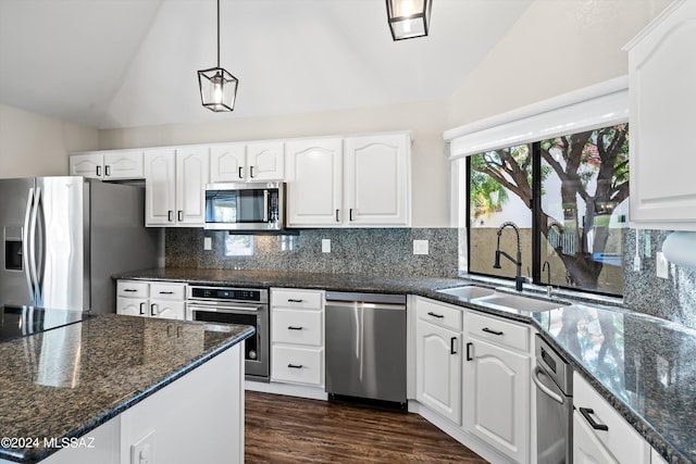 kitchen with white cabinets, appliances with stainless steel finishes, and vaulted ceiling