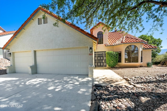 mediterranean / spanish home featuring a garage