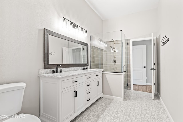 bathroom with tile patterned floors, vanity, toilet, and a shower with door