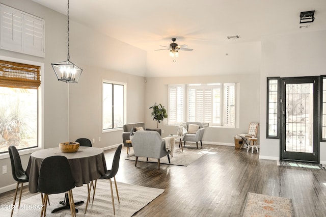 dining space featuring plenty of natural light, dark hardwood / wood-style floors, and ceiling fan with notable chandelier