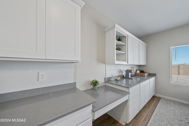 kitchen with decorative backsplash, hardwood / wood-style flooring, and white cabinets