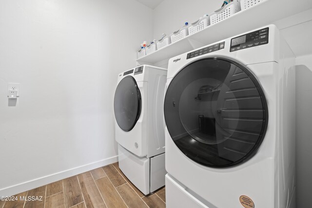 laundry room featuring washing machine and clothes dryer and light wood-type flooring