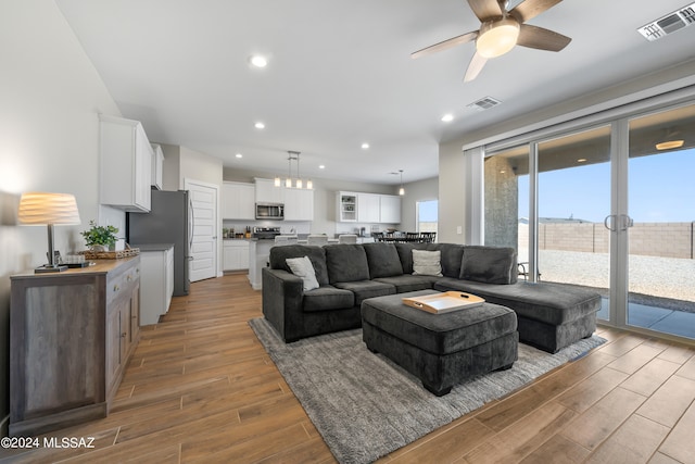 living room featuring ceiling fan and light hardwood / wood-style floors