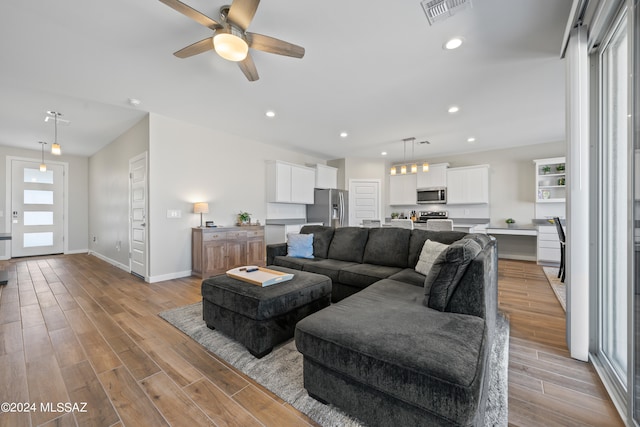 living room featuring light wood-type flooring and ceiling fan