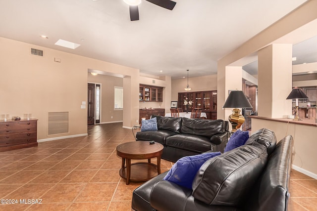 living room with ceiling fan and tile patterned flooring