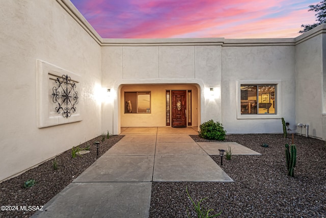 exterior entry at dusk with a patio