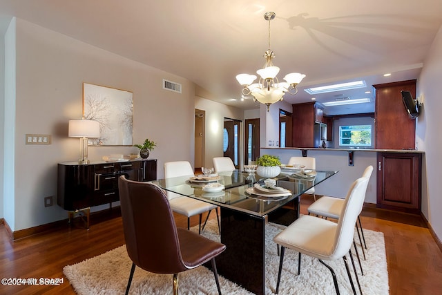 dining space with dark hardwood / wood-style flooring and a chandelier