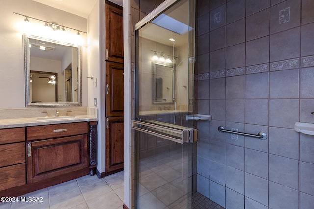 bathroom featuring tile patterned floors, vanity, tile walls, and a shower stall