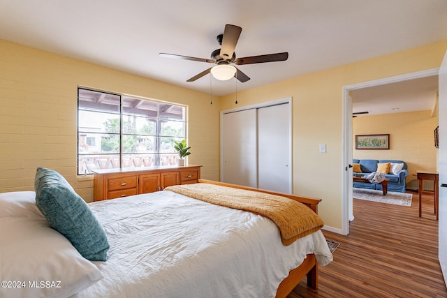 bedroom with a closet, ceiling fan, and dark hardwood / wood-style flooring